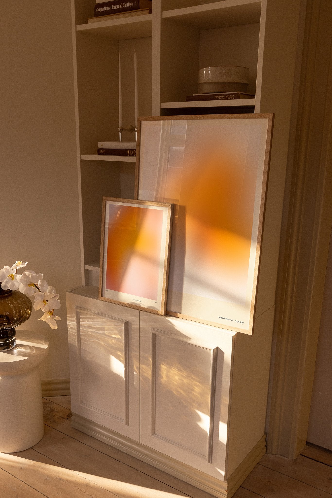 Colorful orange art posters on bookshelf